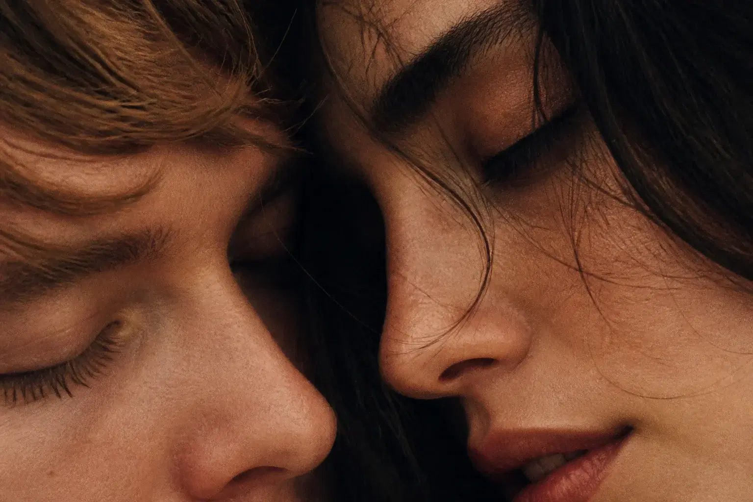 Extreme close-up of an adult couple with eyes closed and faces almost touching